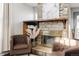 Cozy living room with a stone fireplace, decorative accents, and comfortable arm chairs at 7883 S Windermere Cir, Littleton, CO 80120
