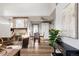 Open concept living room featuring a fireplace, hardwood floors, and white cabinetry at 7883 S Windermere Cir, Littleton, CO 80120