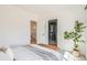 Bright bedroom with white walls featuring a plant and view of an ensuite bathroom at 3649 W 21St Ave, Denver, CO 80211