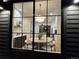 View from outside into the dining room and kitchen, featuring a modern chandelier and sleek cabinetry at 3649 W 21St Ave, Denver, CO 80211
