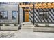 Inviting front entrance with a modern pergola, dark gray siding, and well-maintained landscaping at 3649 W 21St Ave, Denver, CO 80211