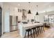 Open kitchen boasts a stainless fridge, waterfall island with seating, and adjacent dining space at 3649 W 21St Ave, Denver, CO 80211