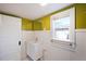 Bathroom featuring a modern vanity, a gold framed mirror, white wainscoting and a window at 422 Atwood St, Longmont, CO 80501