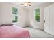 Bright bedroom featuring two windows, a ceiling fan, neutral paint, and carpeted floors at 422 Atwood St, Longmont, CO 80501