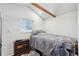 Neutral bedroom with a sloped ceiling, exposed beam, and comfortable bed; filled with natural light at 422 Atwood St, Longmont, CO 80501