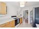A bright kitchen with light wood cabinets, white counters, a black and white range, and tiled floors at 422 Atwood St, Longmont, CO 80501