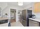 Bright kitchen with stainless steel appliances and a view into the bathroom featuring white walls and fixtures at 422 Atwood St, Longmont, CO 80501
