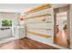 Bright laundry room with washer, dryer, wood shelves, wood floor, and backyard view at 422 Atwood St, Longmont, CO 80501