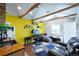 Vibrant living room boasts wooden beams, yellow accent wall and open layout to the kitchen at 422 Atwood St, Longmont, CO 80501
