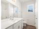 Bathroom featuring white cabinets, a large mirror, and a shower with a glass door at 9069 Pitkin St, Commerce City, CO 80022