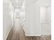 Bright hallway with wood floors and doors, leading to various rooms within the home at 9069 Pitkin St, Commerce City, CO 80022