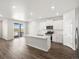 Bright, open kitchen featuring white cabinets, stainless steel appliances, and access to a deck at 9069 Pitkin St, Commerce City, CO 80022