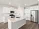 Kitchen with a large island, stainless steel appliances, white cabinetry, and modern finishes at 9069 Pitkin St, Commerce City, CO 80022
