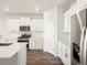 Kitchen featuring white cabinets, stainless steel appliances, and an island with seating at 9069 Pitkin St, Commerce City, CO 80022