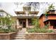 Charming two-story home with brick facade, landscaped front yard, and inviting front porch at 1267 Clayton St, Denver, CO 80206