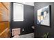Charming powder room features dark paint, a pink toilet, and a stylish piece of art at 1267 Clayton St, Denver, CO 80206