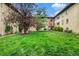 Charming apartment building showcasing a lush green lawn, mature trees, and inviting outdoor seating at 665 Washington St # 5B, Denver, CO 80203