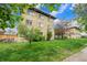Charming brick apartment building surrounded by lush green lawn and mature trees under a bright sky at 665 Washington St # 5B, Denver, CO 80203