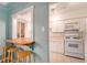Charming kitchen pass-through with bar seating and modern white appliances at 665 Washington St # 5B, Denver, CO 80203