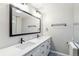 Bright modern bathroom with a double sink vanity, quartz countertop, and a large mirror at 6330 E Vassar Ave, Denver, CO 80222