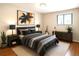 Comfortable bedroom featuring a queen bed, stylish lamps, guitar and modern artwork, creating a relaxed atmosphere at 6330 E Vassar Ave, Denver, CO 80222