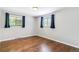 Bright bedroom features hardwood floors and natural light from two windows at 6330 E Vassar Ave, Denver, CO 80222