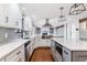Well-lit modern kitchen with white cabinets, stainless steel appliances, and an island with quartz countertops at 6330 E Vassar Ave, Denver, CO 80222