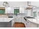 Well-equipped kitchen with white cabinets, stainless steel range hood, and a view to the back yard at 6330 E Vassar Ave, Denver, CO 80222