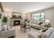 Cozy living room with a brick fireplace, neutral furniture, and a large picture window at 6330 E Vassar Ave, Denver, CO 80222