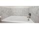 Bright white bathtub and modern marble tile in a newly renovated bathroom at 3131 E Alameda Ave # 1107, Denver, CO 80209