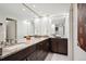 Bathroom featuring a double vanity with dark wood cabinets, granite countertops, and marble floors at 3131 E Alameda Ave # 1107, Denver, CO 80209