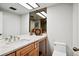 A modern bathroom with a granite countertop, wood cabinets, and contemporary fixtures at 3131 E Alameda Ave # 1107, Denver, CO 80209