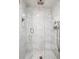 Shower featuring marble tile, glass enclosure, rainfall showerhead, and a handheld shower fixture at 3131 E Alameda Ave # 1107, Denver, CO 80209