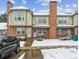 Brick townhome with snow-covered front yard and steps leading to the entrance at 3006 W 107Th Pl # D, Westminster, CO 80031