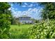 Back exterior view of a two-story home framed by lush green trees and greenery at 1106 Oak Cir, Lakewood, CO 80215