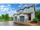 Beautiful townhome featuring two-car garage, stone accents, and manicured landscaping on a wet day at 1106 Oak Cir, Lakewood, CO 80215