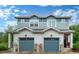 Charming duplex with blue siding and matching garage doors, showcasing modern curb appeal at 1106 Oak Cir, Lakewood, CO 80215