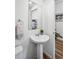 A cute half bathroom with a pedestal sink, mirror and decorative towel at 1106 Oak Cir, Lakewood, CO 80215