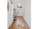 Inviting hallway with light wood floors, white walls, and a view of the front door at 1106 Oak Cir, Lakewood, CO 80215