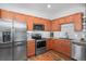 Modern kitchen with stainless steel appliances, wood cabinets, granite counters, and hardwood floors at 1106 Oak Cir, Lakewood, CO 80215