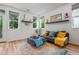 Bright living room with stylish decor, floating shelves, and large windows offering natural light at 1106 Oak Cir, Lakewood, CO 80215