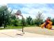 Community park featuring a basketball court and play area with mature trees in the background at 1106 Oak Cir, Lakewood, CO 80215
