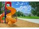 Community playground featuring a vibrant yellow spiral slide against a backdrop of green lawn and townhomes at 1106 Oak Cir, Lakewood, CO 80215