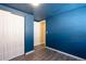 Cozy bedroom with a large closet, blue painted walls, and laminate flooring at 6500 E 88Th Ave # 258, Henderson, CO 80640