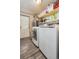 Well-equipped laundry room with washer, dryer, shelves, and laminate flooring at 6500 E 88Th Ave # 258, Henderson, CO 80640