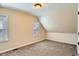 Empty carpeted bedroom featuring slanted ceilings and natural light at 3047 Osceola St, Denver, CO 80212
