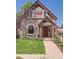 Charming two-story home featuring a well-manicured lawn, mature trees, and a welcoming red-trimmed entrance at 3047 Osceola St, Denver, CO 80212