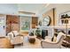 Cozy living room featuring exposed brick, a fireplace, hardwood floors, and lots of natural light from a large window at 3047 Osceola St, Denver, CO 80212