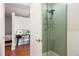 Bathroom with a glass-enclosed shower, modern fixtures, and view to bedroom at 2958 Syracuse St # 306, Denver, CO 80238