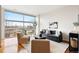 Bright living room featuring modern furnishings, large windows, and hardwood floors at 2958 Syracuse St # 306, Denver, CO 80238